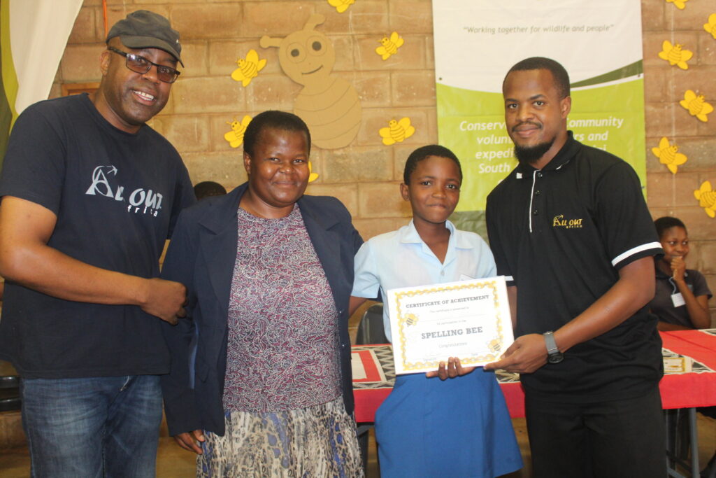 Tjengisa, NCP Teacher and Simise awarding a certificate to one of the homework club students.